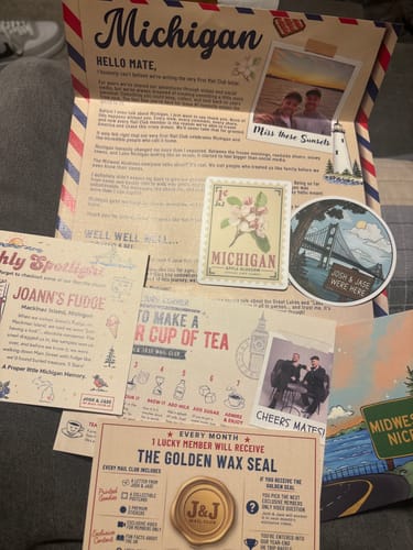 Customer's J&J Mail Club Michigan edition package contents spread out, including letter, postcards, and stickers.