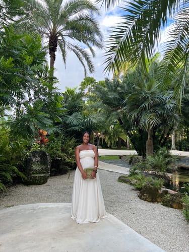Customer's off-white Linen Tube Maxi Dress worn by a pregnant person in a tropical outdoor setting.