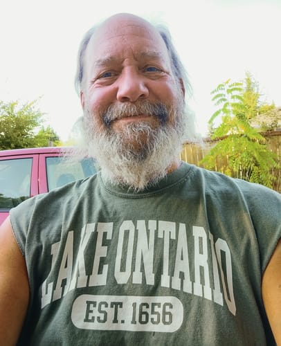 Customer wearing the green Lake Ontario Varsity T-Shirt with the sleeves removed.