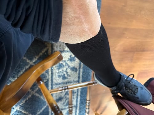 Customer's black Eucalyptus Lyocell Compression Socks worn on the lower leg while sitting in a chair.