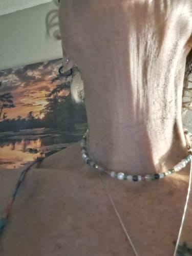 Reviewer wearing the Tropicana Pearl Necklace, featuring small iridescent pearls.