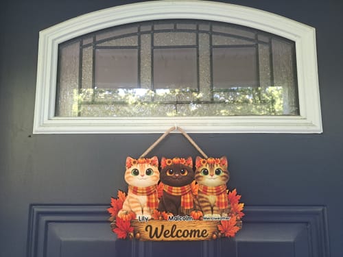 Customer's Fall Cats Welcome Door Sign featuring three personalized cats hanging on a dark blue front door.