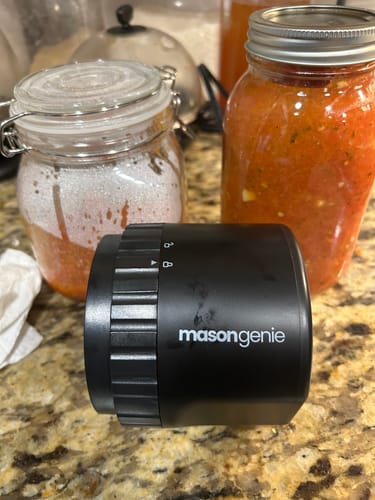 Customer's Mason Genie vacuum sealer on a kitchen counter next to two glass jars.