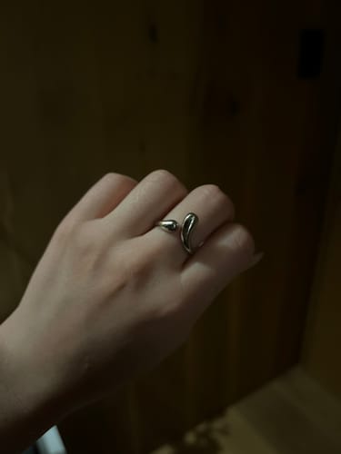 Customer's Anillo Ajustable Juliana Plata puesto en un dedo, mostrando su diseño metálico y forma abierta.