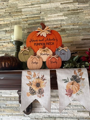 Customer's personalized pumpkin door hanger displayed on a fireplace mantle amidst autumn decorations.