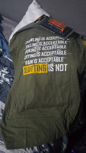Customer's Keep Moving Forward shirt, dark green, with inspirational text, and a tool set resting on top.
