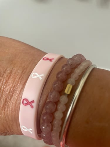 Customer's STACKER - PINK QUARTS bracelet worn on a wrist alongside other beaded and metal stackable bracelets.