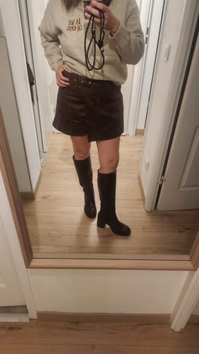 Customer's Bottes MAÉ en coloris chocolat portées avec une jupe, vues dans un miroir.