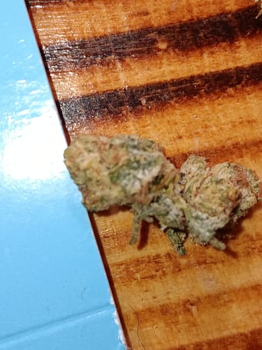 Customer's Purple Punch THCA micro buds on a wooden surface, close-up view.
