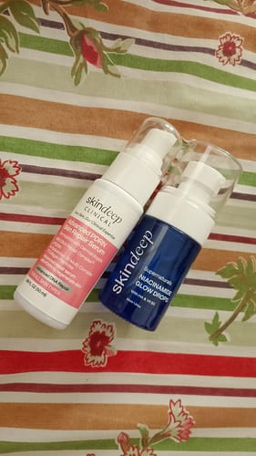 Customer's Niacinamide Glow Drops and Advanced PDRN Skin Repair Serum bottles sitting on a floral surface.