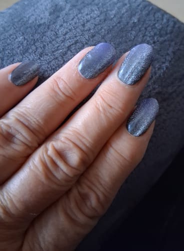 Customer's Midnight Cateye nail wraps applied to fingernails, displaying a shimmering dark purple and black design.