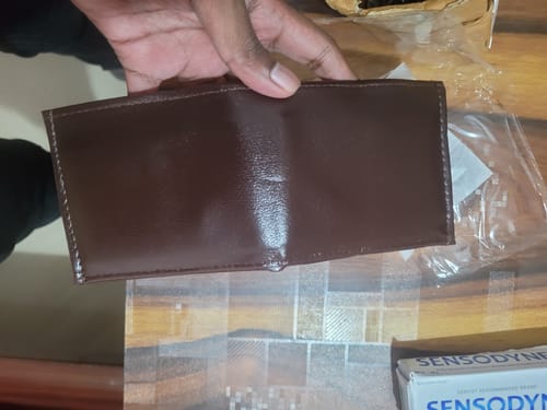 Customer's brown synthetic wallet held in hand.