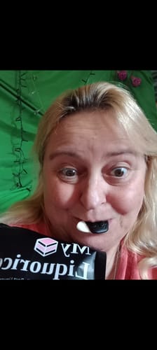 Customer's Discovery Liquorice Bundle, holding a piece of black and white liquorice to their mouth.