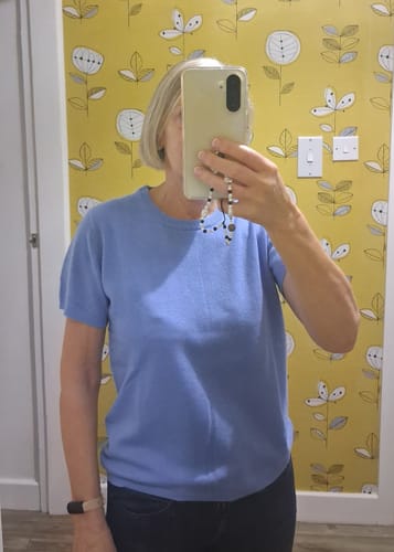 Customer's cornflower blue cashmere crew neck t-shirt worn by a person in a mirror selfie.