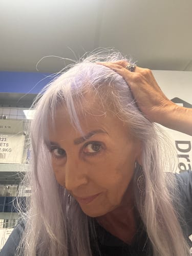 Customer with long silver hair showing her new growth, customer photo