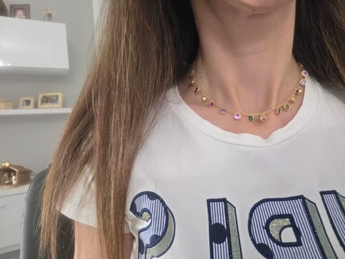 Customer's collarino con ciondoli colorati indossato al collo, mostra le pietre vivaci e la catena dorata.
