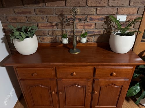 Customer's Nimes French Provincial Balance Scales with small plants in the dishes, displayed on a wooden cabinet.