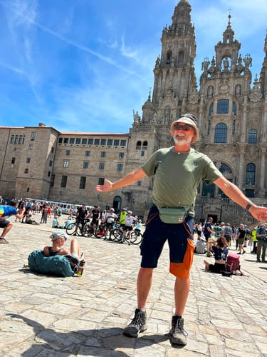 Customer's Merino Shirt Herren in grün getragen vor einer großen historischen Kathedrale während einer Wanderreise