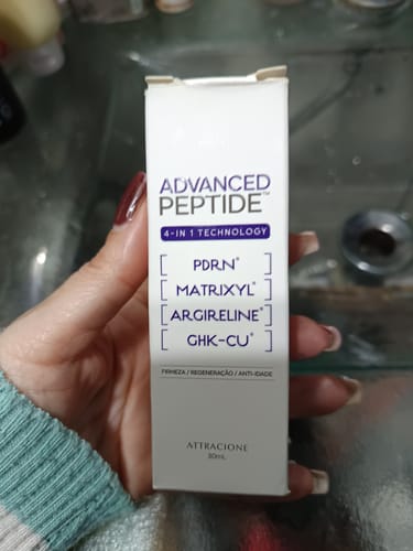Customer's hand holding the white rectangular box of Advanced Peptide serum.