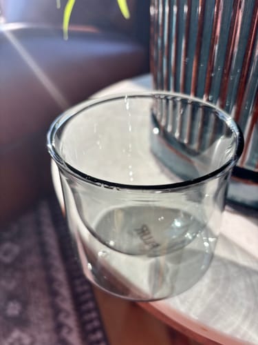 Customer's clear glass FLUR Latte XL cup sitting on a surface, viewed from above.