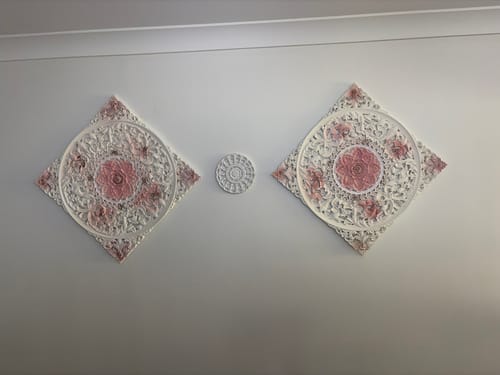 Customer's two Louis Carved Mandala Wall Art panels mounted on a wall with a small circular accent piece in between.