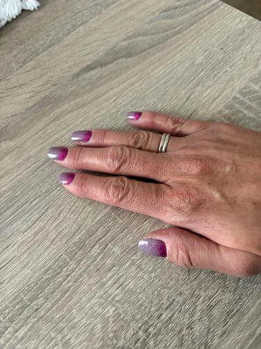 Customer's hand wearing Time To Party UV Gel Nail Wraps with a glittery pink-nude gradient finish.
