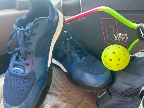 Customer's blue Extra Comfort Support Insoles worn as shoes, next to a pickleball paddle and yellow ball.