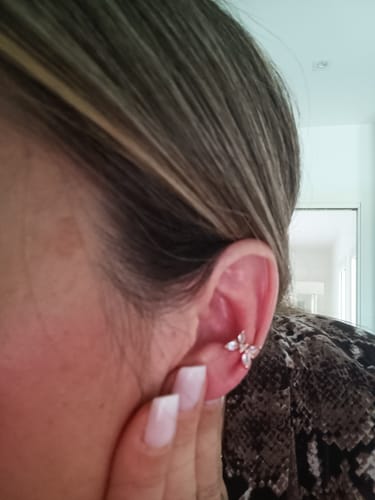 Reviewer's ear wearing a luminous Orecchino Ear Cuff Farfallina featuring a delicate butterfly design.