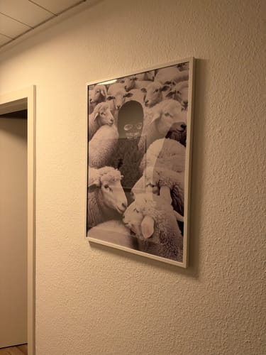 Customer's Built Different art print in a white frame, hanging on a textured wall.
