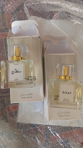 Customer's two glass perfume bottles with rectangular labels, sitting inside open product packaging.