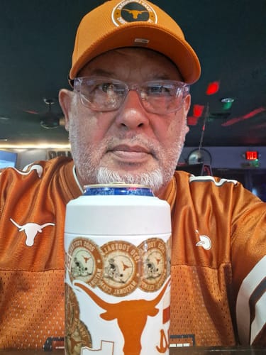 Customer's Universal Buddy Texas Longhorns sticker can cooler held in front of a person wearing an orange team hat.