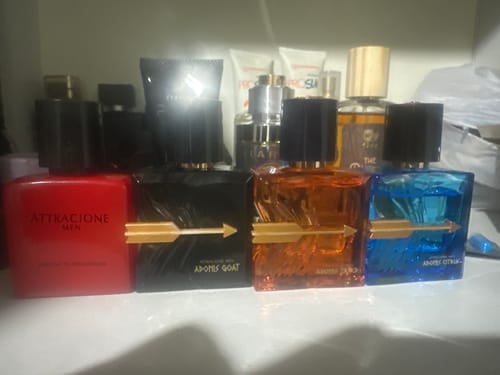 Customer's Kit Adonis and Attracione Men perfume bottles lined up on a shelf.