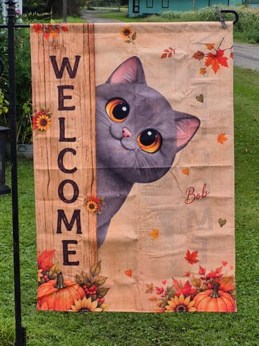 Customer's personalized Cozy Fall Cat Welcome flag with a grey cat illustration, outdoor setting.