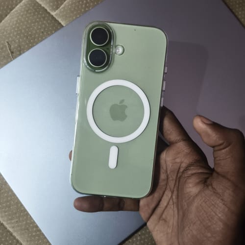 Customer's hand holding a clear iPhone 17 case with a white MagSafe ring, showing the phone's green back.