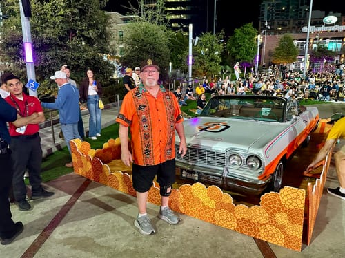 Reviewer's Viva Los Muertos Guayabera worn at a stadium event, standing next to a vintage car.