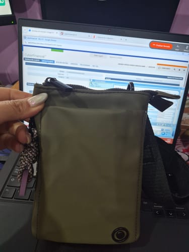 Reviewer's hand holding a khaki Mini Cartera Llavero Ready To Go with a keychain.