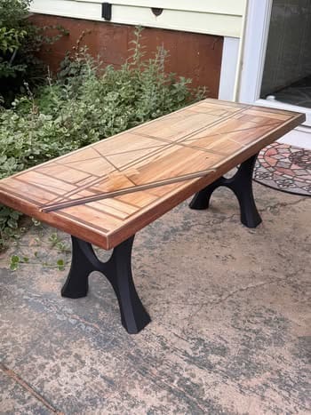 Customer's Bench Legs 103 Haru attached to a wooden tabletop on a patio.