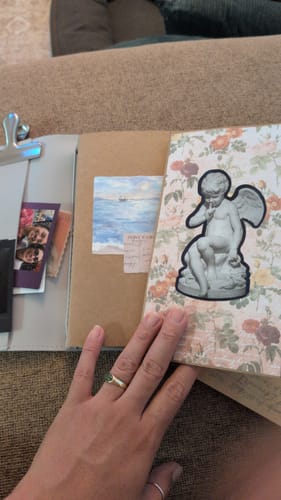 Customer's TN Notebook Refill Insert customized with decorative stickers and photos, held by a hand.