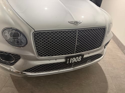 Reviewer's white Bentley Bentayga featuring the sleek, installed OEM Plinth Delete Kit with a floating number plate.