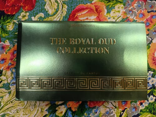Customer's green Royal Oud Collection box with gold lettering on a patterned floral surface.
