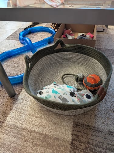 Customer's Fellnest Katzenkorb in green and white, filled with a patterned blanket and toy on a carpet floor.