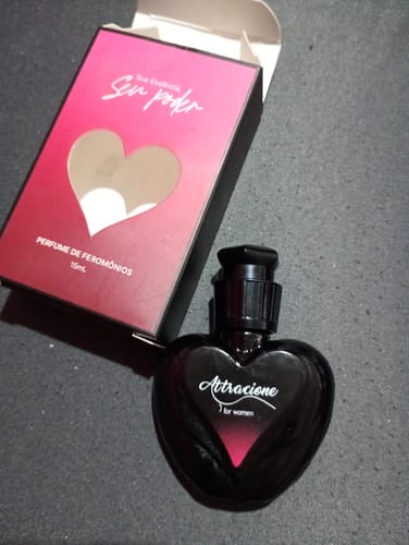 Customer's Attracione Sensual perfume bottle in heart shape next to its pink and red box.