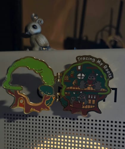 Customer's Tracing My Roots pin opened, revealing tree interior design, attached to a magnetic surface.