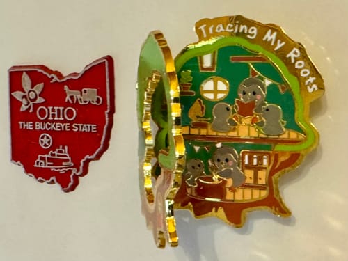 Reviewer's Tracing My Roots Pin and Magnet on a magnetic surface, shown open to reveal bird characters inside.