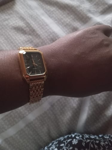 Reviewer's wrist wearing a gold-toned Claire De Mains watch with a black dial and detailed metallic band.