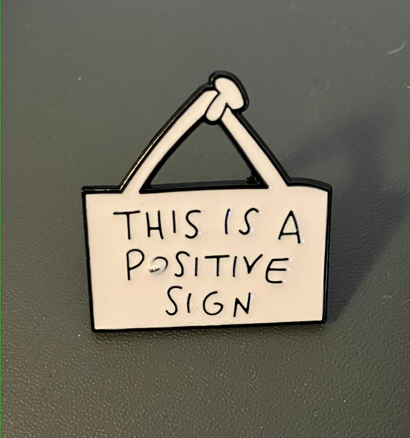 Customer photo review of This Is a Positive Sign Enamel Pin | Motivational Quote Pin