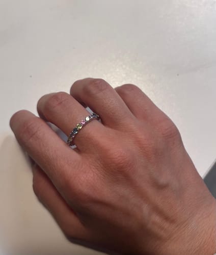 Customer's hand wearing the Anello Tennis in Zirconi Arcobaleno with colorful stones.