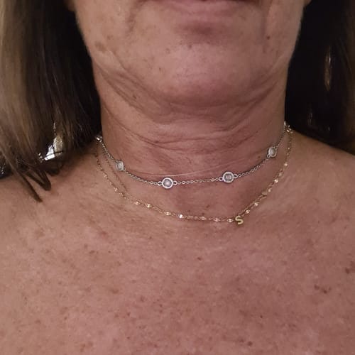 Customer's Collana Fine con Castoncini in Zirconi indossata, mostra la collana con zirconi e una catenina sottile con ciondolo S
