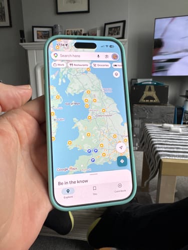 Customer's Apple iPhone 16 Pro in a light blue case, held in a hand showing a map on the screen.