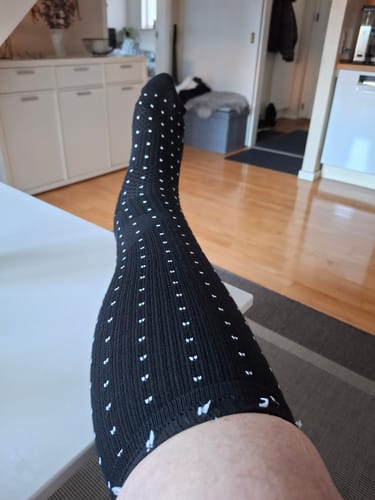 Customer's Diasocks støttestrømper, sort strømpe med hvidt prikmønster på benet.